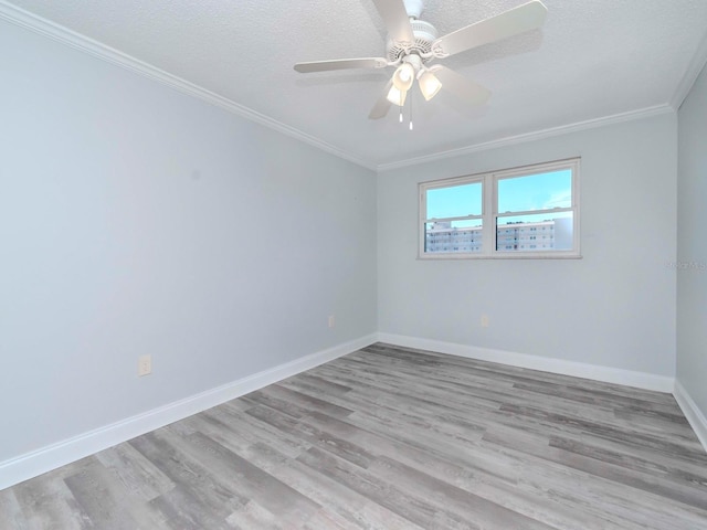 unfurnished room with a textured ceiling, wood finished floors, a ceiling fan, baseboards, and ornamental molding