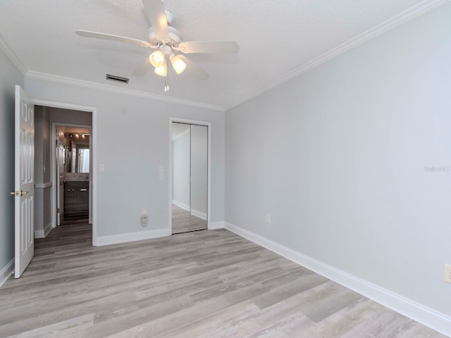 unfurnished bedroom with ornamental molding, light wood-style flooring, and baseboards