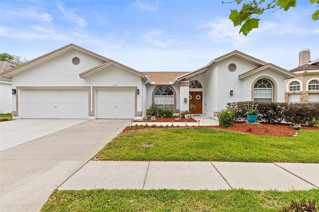 view of front of house featuring a garage, a front yard, stucco siding, and concrete driveway
