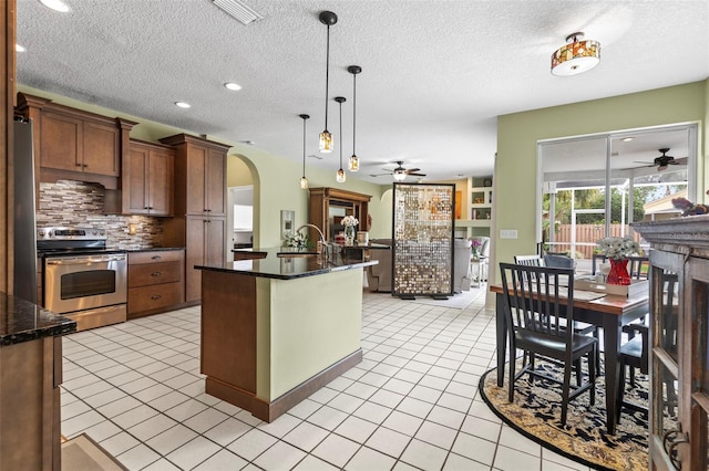 kitchen with arched walkways, appliances with stainless steel finishes, ceiling fan, and visible vents