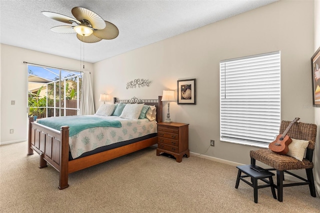 bedroom featuring ceiling fan, a textured ceiling, light colored carpet, and baseboards