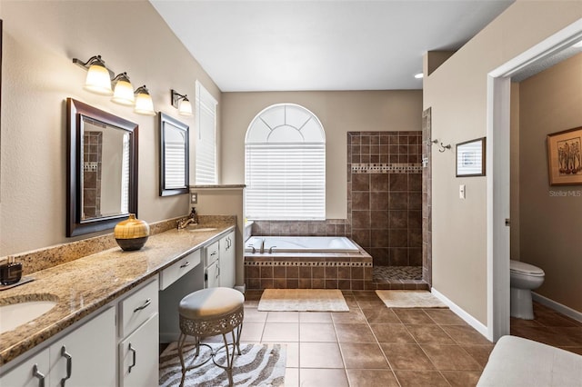 bathroom featuring a walk in shower, a garden tub, tile patterned flooring, toilet, and double vanity