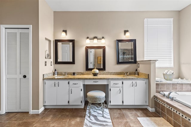 full bathroom featuring a closet, double vanity, a sink, and tile patterned flooring