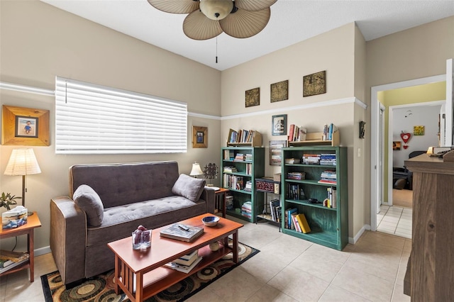 living room featuring light tile patterned floors, baseboards, and a ceiling fan