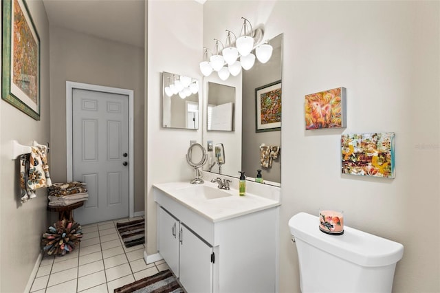 bathroom with toilet, vanity, baseboards, and tile patterned flooring