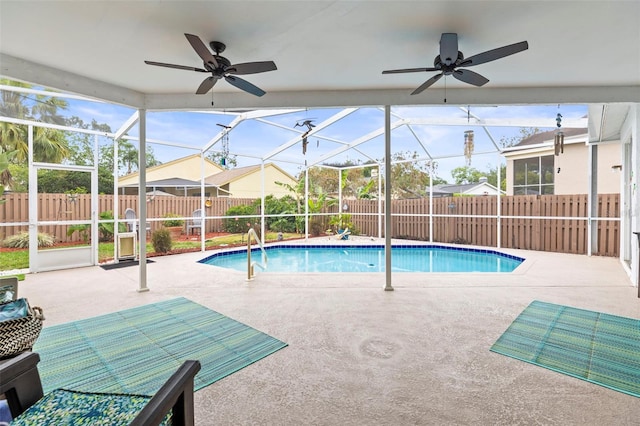 view of swimming pool featuring a patio, a fenced backyard, and glass enclosure