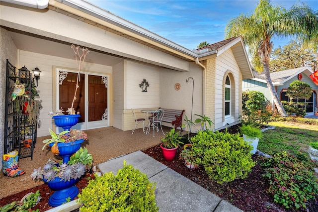 entrance to property featuring a patio area and brick siding