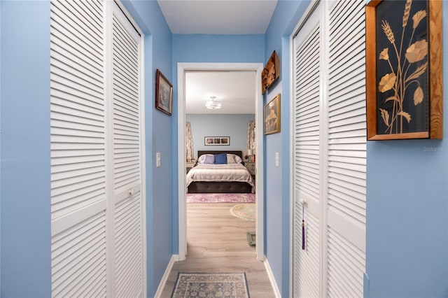 hallway with baseboards and wood finished floors