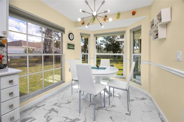 sunroom / solarium with a wealth of natural light and a notable chandelier