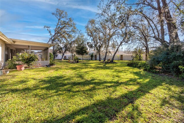 view of yard with a fenced backyard and a sunroom