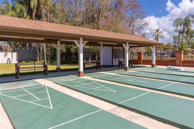 surrounding community with fence and shuffleboard