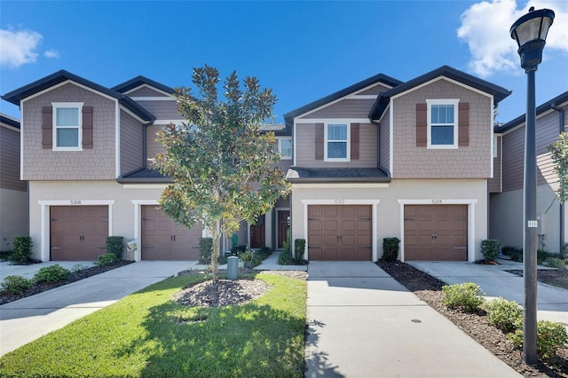 view of front of house featuring concrete driveway, an attached garage, and stucco siding