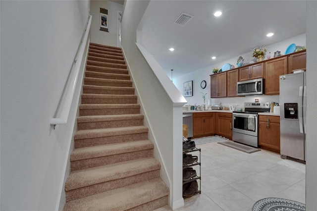 kitchen featuring recessed lighting, light countertops, visible vents, appliances with stainless steel finishes, and brown cabinetry