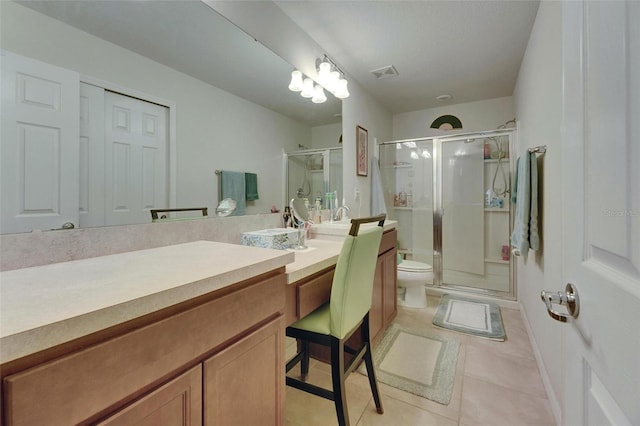 bathroom featuring tile patterned flooring, toilet, vanity, visible vents, and a shower stall