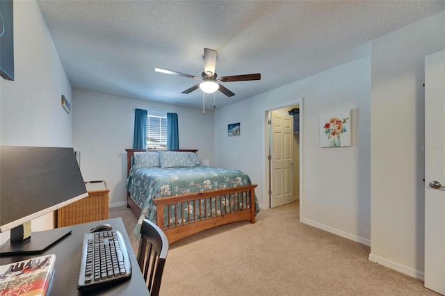 carpeted bedroom with a textured ceiling, ceiling fan, and baseboards