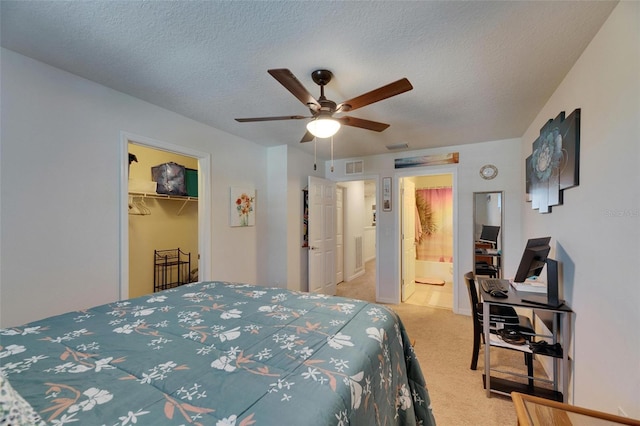 carpeted bedroom featuring connected bathroom, ceiling fan, a spacious closet, a textured ceiling, and a closet