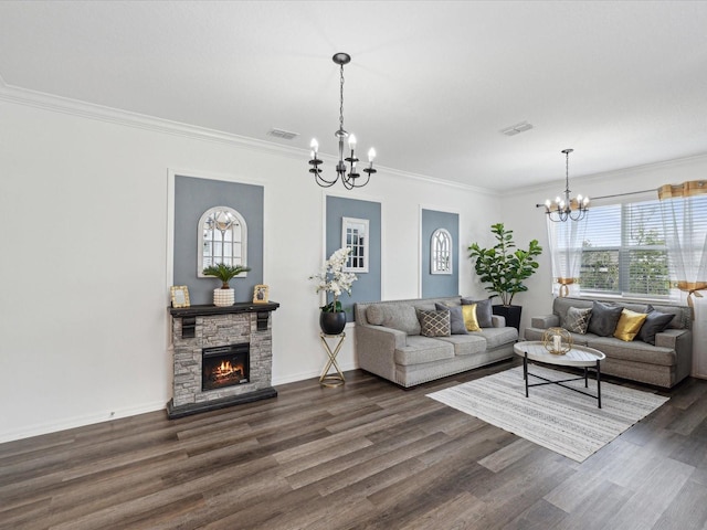 living room with visible vents, a chandelier, dark wood finished floors, and a stone fireplace