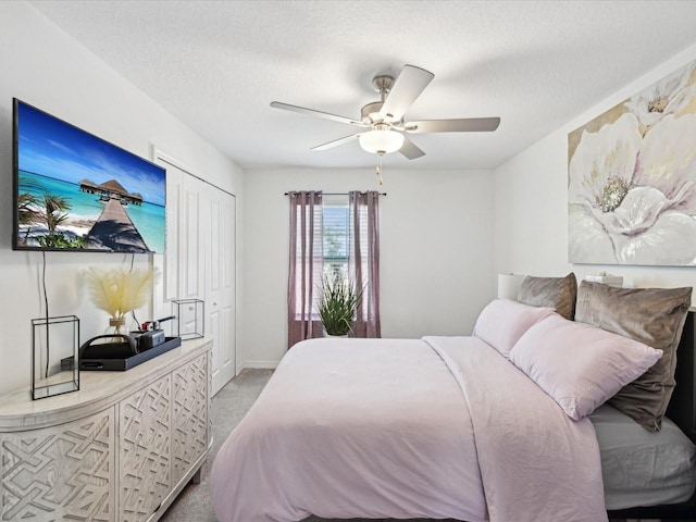 carpeted bedroom with a textured ceiling, ceiling fan, and baseboards