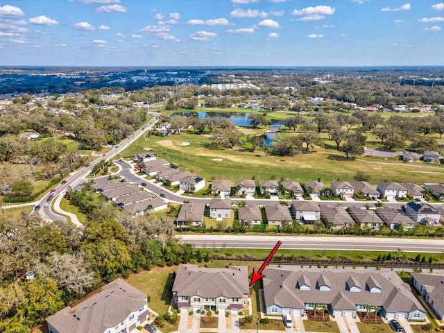 drone / aerial view with a water view, view of golf course, and a residential view