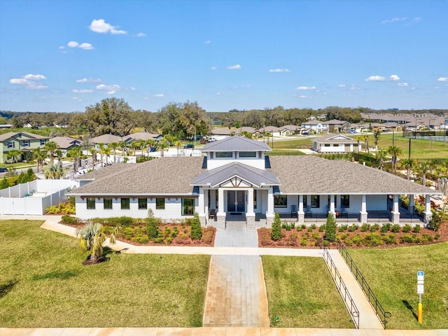 view of front of house featuring a residential view, fence, and a front lawn