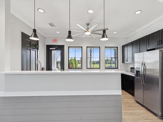 kitchen with light wood-style flooring, visible vents, light countertops, ornamental molding, and stainless steel fridge with ice dispenser