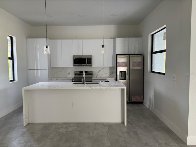 9 Tee View Rd, Rotonda West, FL 33947 - kitchen with stainless steel appliances, white cabinets, healthy amount of natural light, and baseboards