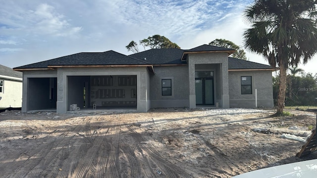 9 Tee View Rd, Rotonda West, FL 33947 - prairie-style house featuring an attached garage, stucco siding, and a shingled roof