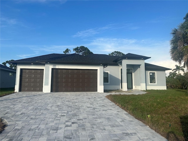 9 Tee View Rd, Rotonda West, FL 33947 - prairie-style house with stucco siding, an attached garage, decorative driveway, and a front yard