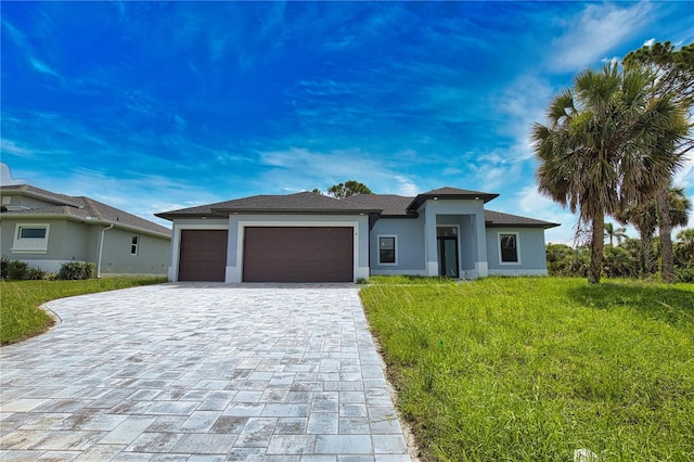 9 Tee View Rd, Rotonda West, FL 33947 - prairie-style house with decorative driveway, an attached garage, a front lawn, and stucco siding