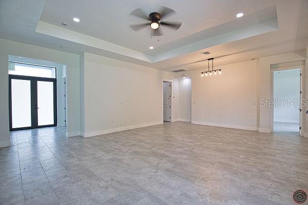 9 Tee View Rd, Rotonda West, FL 33947 - empty room featuring a raised ceiling, french doors, ceiling fan, and recessed lighting