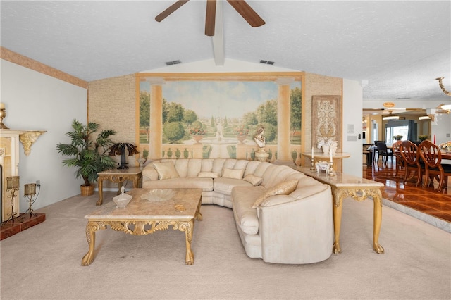 carpeted living area with visible vents, vaulted ceiling with beams, a textured ceiling, and ceiling fan