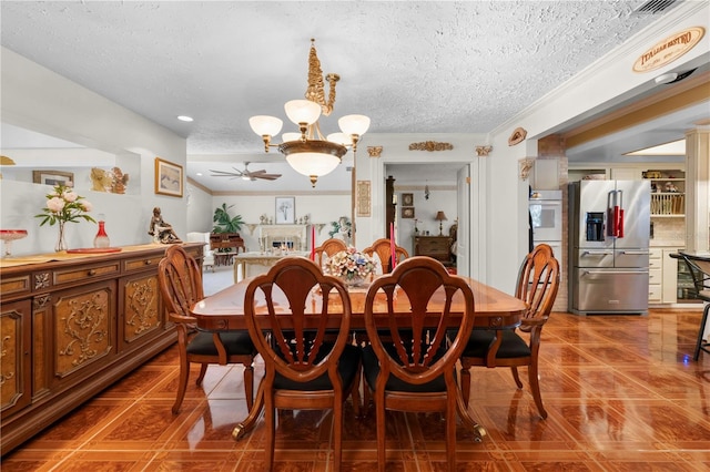 tiled dining area featuring a lit fireplace, crown molding, a textured ceiling, and ceiling fan with notable chandelier