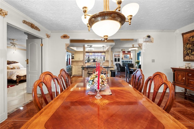 tiled dining room with crown molding, a textured ceiling, and ceiling fan with notable chandelier