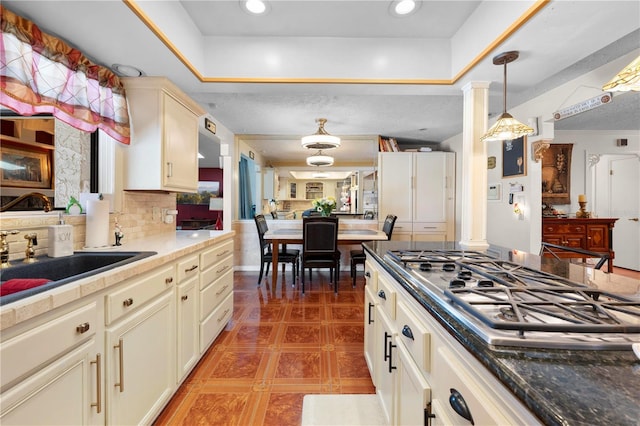 kitchen with pendant lighting, stainless steel gas cooktop, recessed lighting, backsplash, and a sink