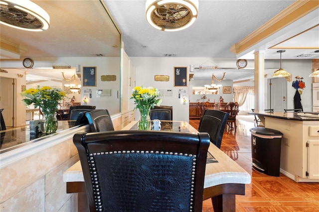 dining area with light tile patterned floors, visible vents, and a textured ceiling