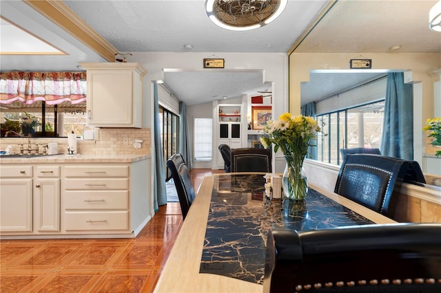 dining area featuring vaulted ceiling and a textured ceiling