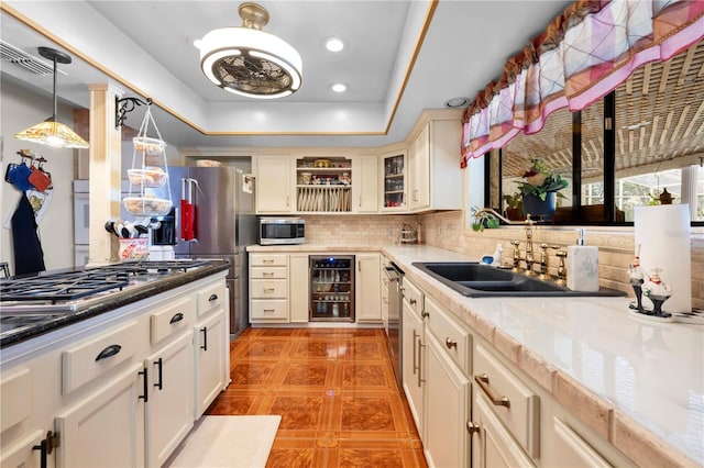 kitchen with stainless steel appliances, decorative backsplash, glass insert cabinets, a sink, and beverage cooler