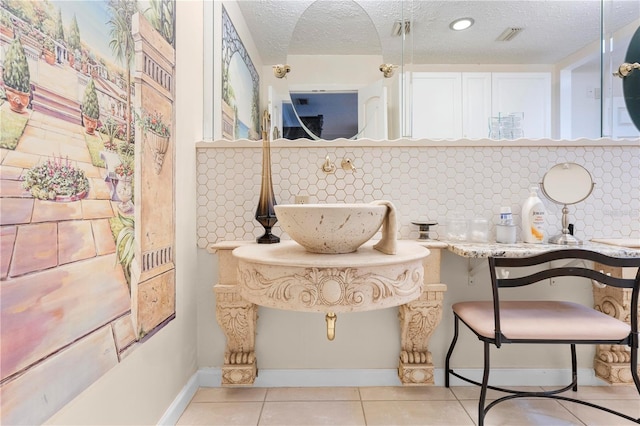 interior space featuring tasteful backsplash, visible vents, a textured ceiling, and tile patterned floors