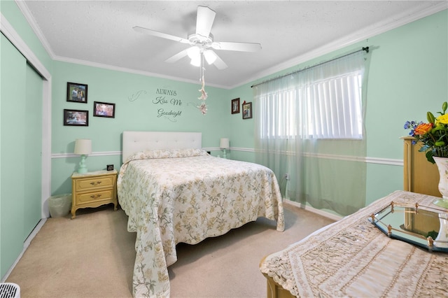 carpeted bedroom featuring ornamental molding, a closet, and ceiling fan