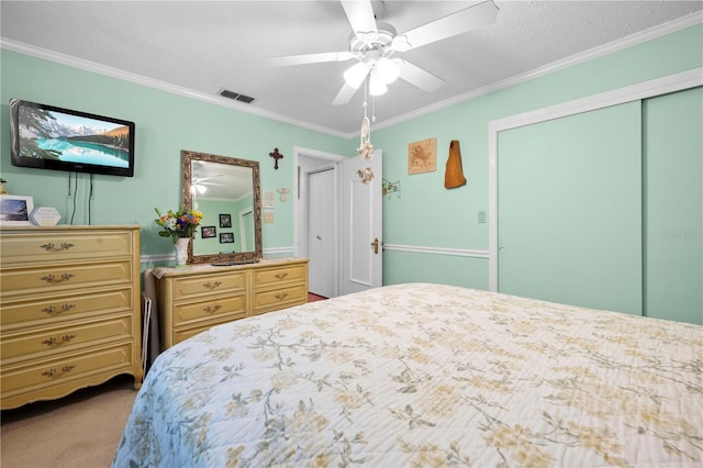 bedroom with ornamental molding, carpet, a closet, and visible vents