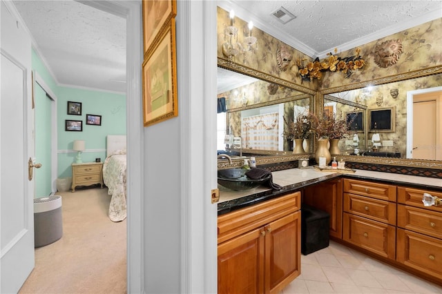 bathroom featuring a textured ceiling, visible vents, vanity, ornamental molding, and wallpapered walls