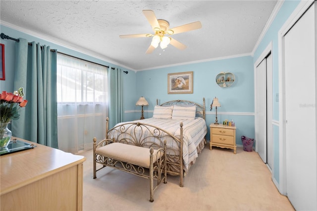 bedroom featuring crown molding, a textured ceiling, a closet, and light colored carpet