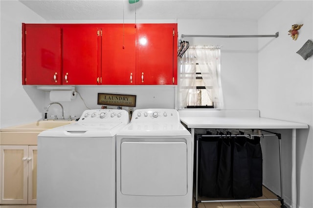 clothes washing area with cabinet space, washer and clothes dryer, and a sink