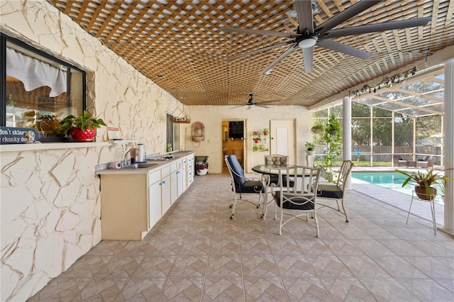 view of patio with glass enclosure, area for grilling, a sink, a fenced in pool, and outdoor dining space