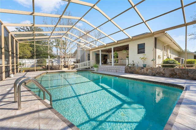 view of pool with a lanai, a patio area, ceiling fan, and a fenced in pool