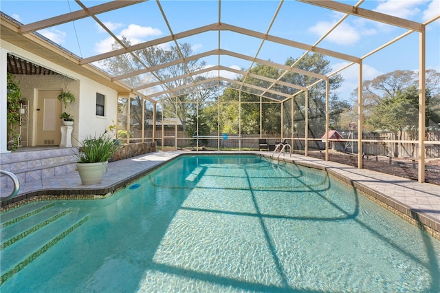 view of pool featuring a patio, glass enclosure, a fenced backyard, and a fenced in pool