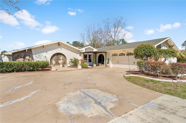 single story home featuring a garage and concrete driveway