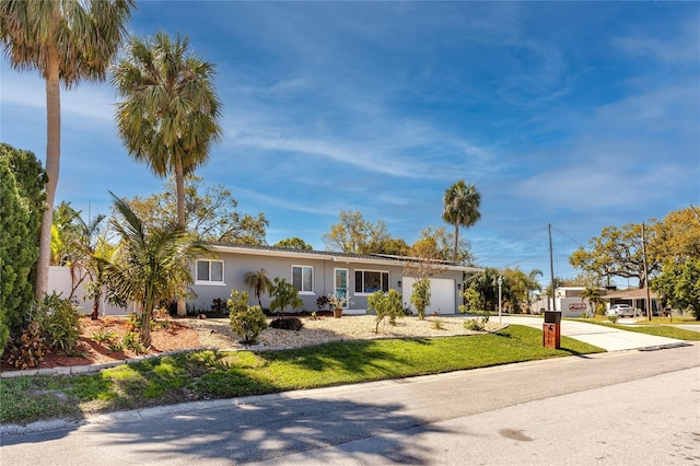 ranch-style house featuring an attached garage, driveway, and stucco siding