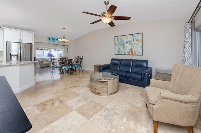 living room featuring baseboards, a ceiling fan, and vaulted ceiling