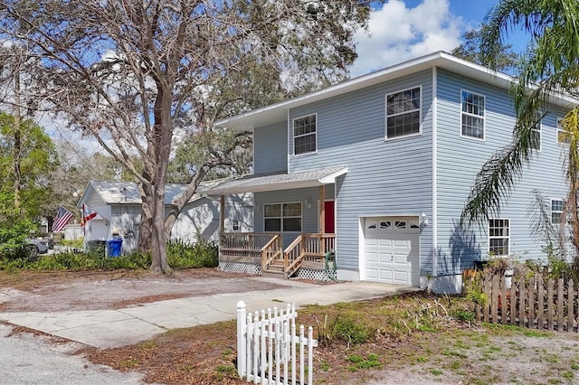 traditional-style home with driveway, an attached garage, fence, and a porch